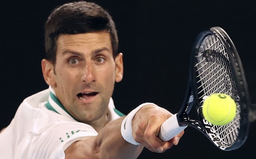 (FILES) In this file photo taken on February 21, 2021, Serbia's Novak Djokovic hits a return against Russia's Daniil Medvedev during their men's singles final match on day fourteen of the Australian Open tennis tournament in Melbourne.
