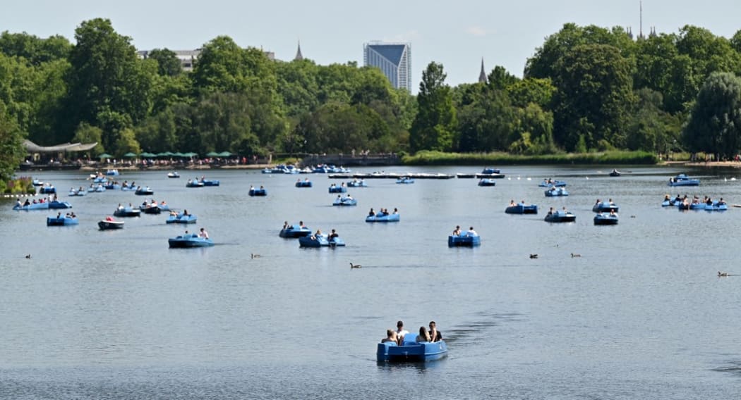 Sun-seekers ride pedalos and row boats on the Serpentine in Hyde Park, central London on July 17, 2021, as forecasters expect the mercury to hit 31C in England, with even higher temperatures forecast for Sunday.
