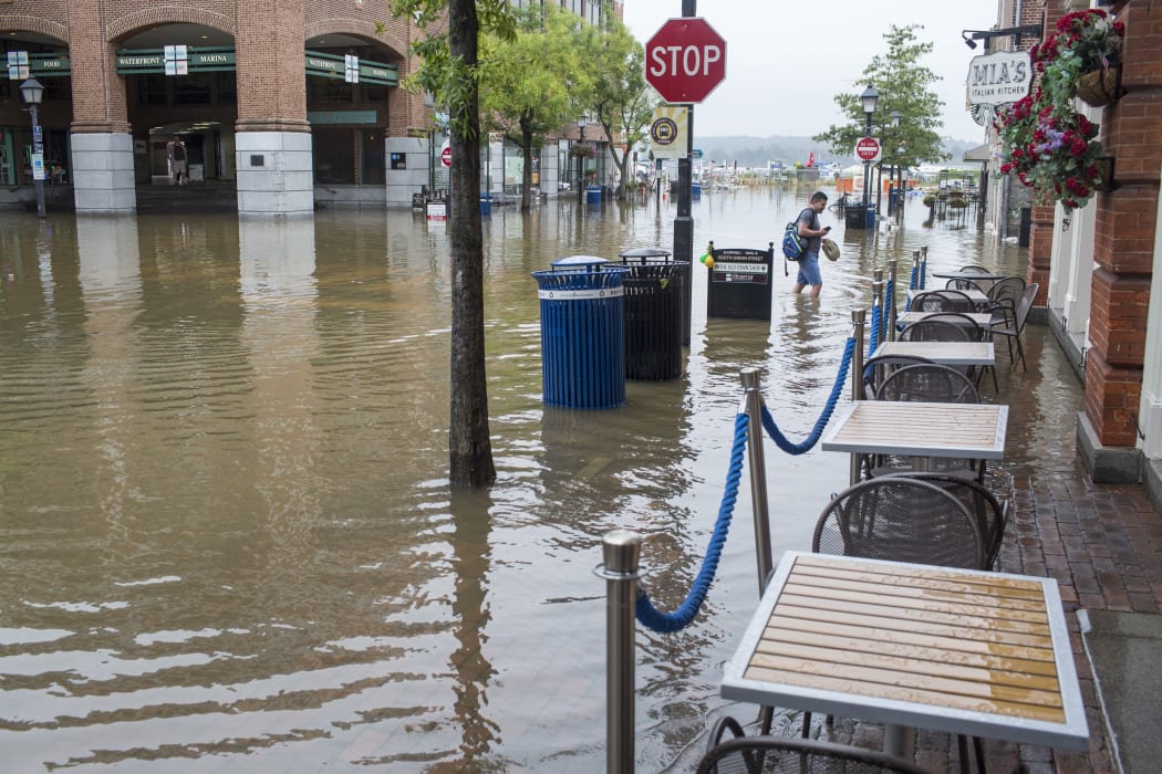 A man walks a flooded street in Old Town Alexandria, Virginia , 11 September 2018.