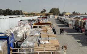 Trucks transporting humanitarian aid wait to enter through the Egyptian side of the Rafah border crossing with the Gaza Strip in northeastern Egypt on January 27, 2026, as the vital crossing to the Palestinian territory reopens.