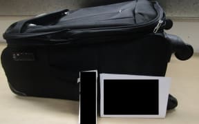Cocaine packs were discovered in a false bottom suitcase.