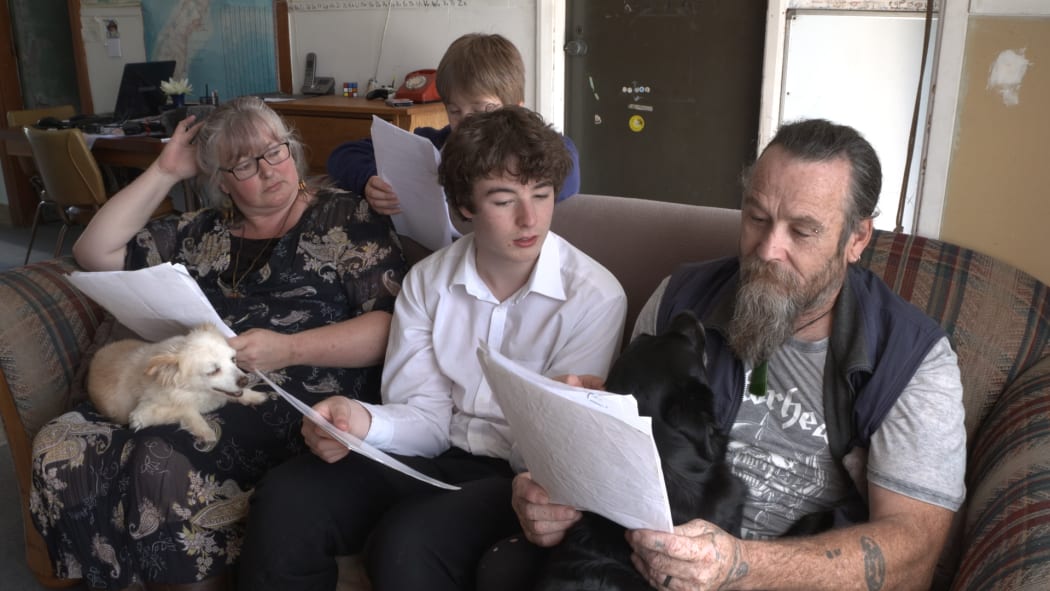 The Lambert family - Stephanie Logan, Cairo and Chris - look through documents about their insurance.