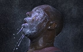 A man is doused with milk and sprayed with mist after being hit with tear gas during demonstrations on the grand jury's decision not to charge officer who shot Michael Brown.
