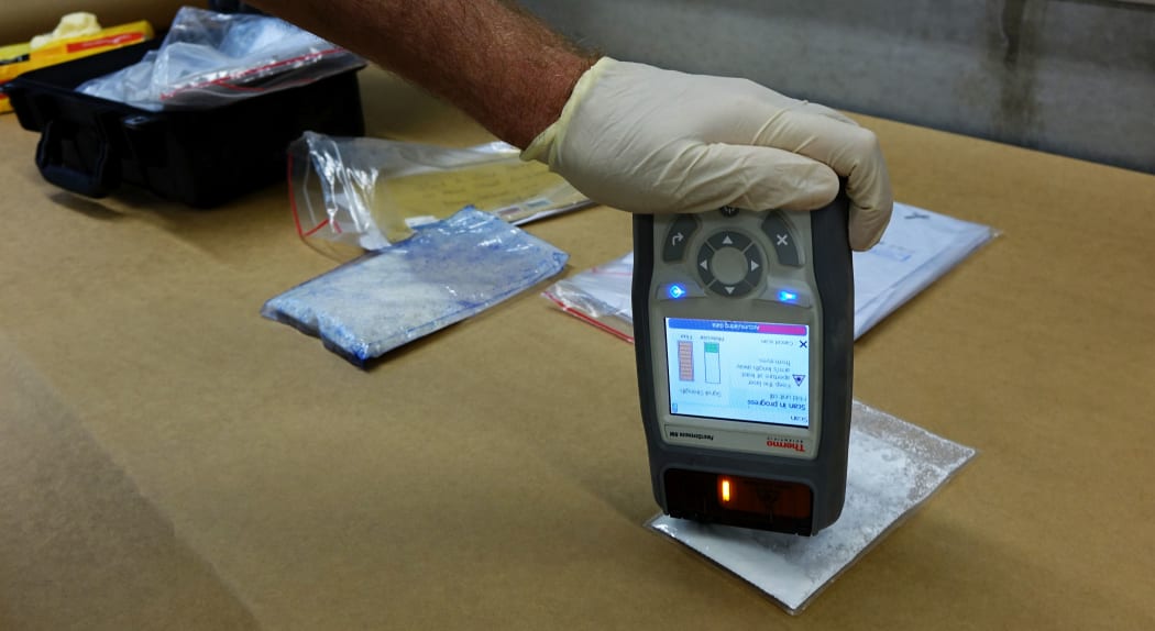 A customs official does a quick test for illicit drugs using the "First Defender" tool - which is a small device that can check for thousands of narcotics in seconds