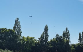 A FENZ helicopter carrying a monsoon bucket near the Kirwee bush fire 5 February 2024