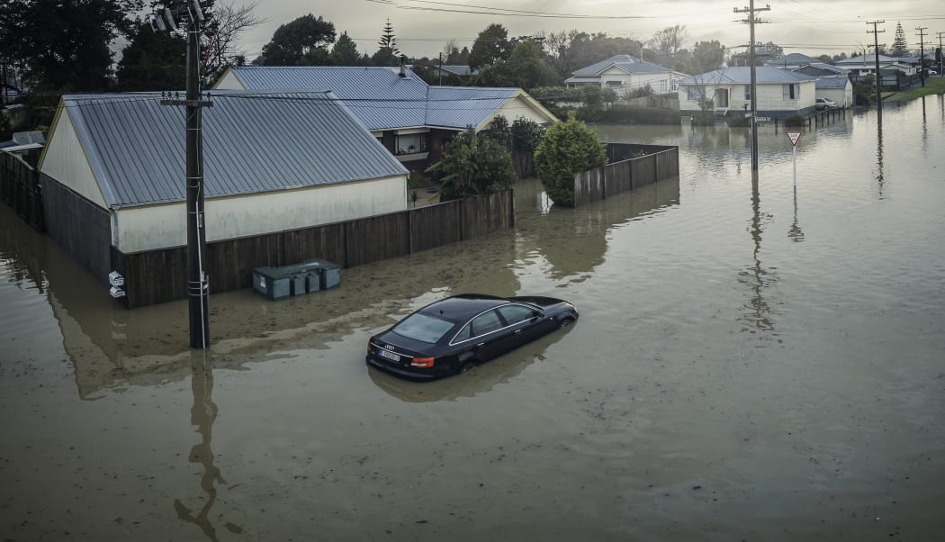 A partly-submerged car outside flooded houses on Disraeli St, Westport.