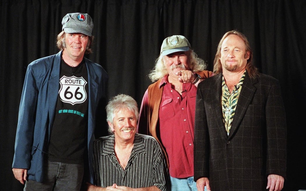 (FILES) In this file photo taken on October 11, 1999 David Crosby (2nd from R) points to an audience member while posing for a photo with once and future bandmates Stephen Stills (R), Graham Nash (2nd from L) and Neil Young before a news conference in New York, where they announced they would be reuniting  and touring for the first time in 25 years. - Folk-rock pioneer David Crosby dies on January 19, 2023, at 81, according to US media (Photo by HENNY RAY ABRAMS / AFP)