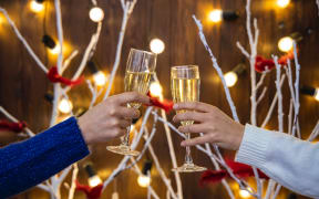 People clinking champagne glasses together in a festive setting.