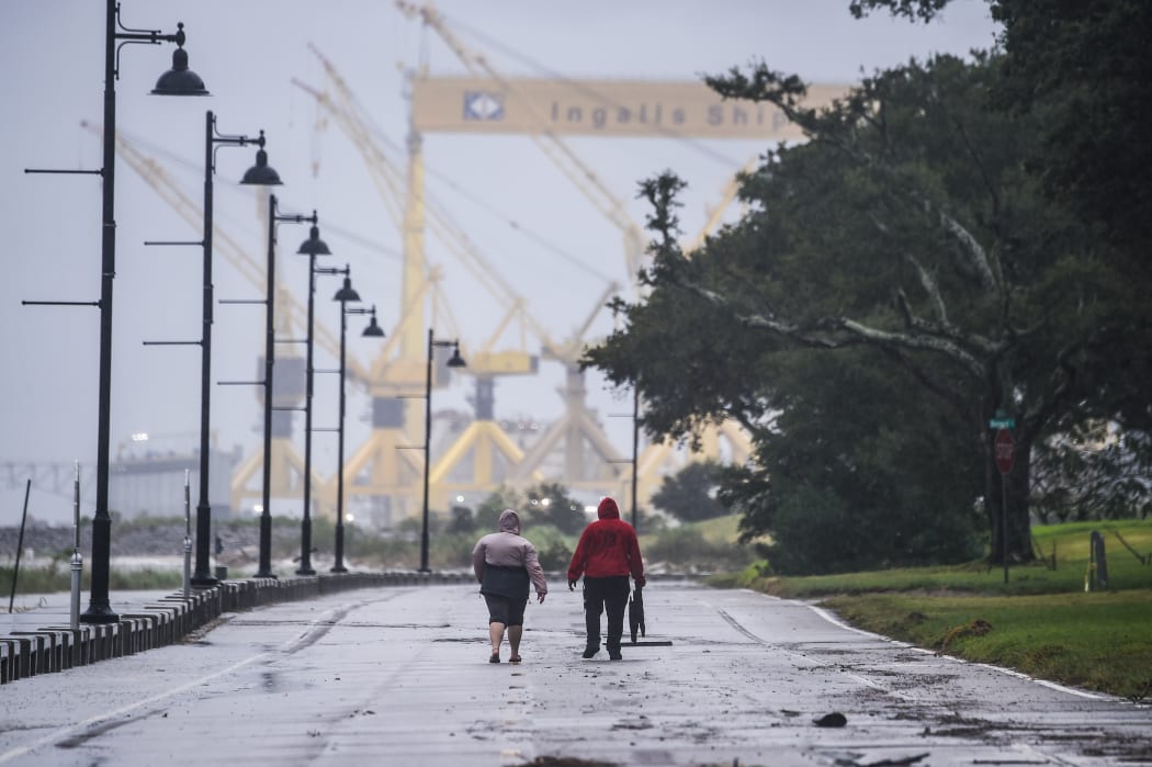 Residents walk on the coastal road hours before Hurricane Sally makes landfall on the US Gulf Coast in Pascagoula, Mississippi on 15 September 2020.