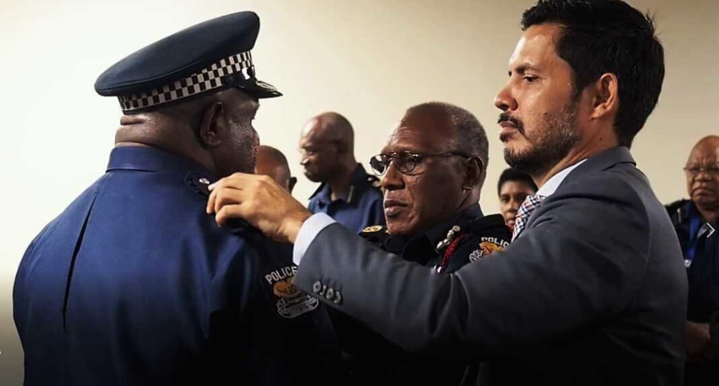 Chief Supritendent  Joe Poma promoted to assistant police commissioner by PNG's Police Minister Bryan Kramer. Former Police Commissioner Gary Baki (middle) observes.