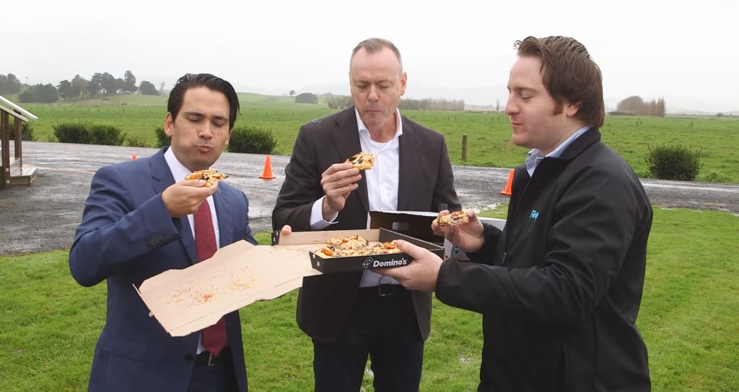 Transport minister Simon Bridges shares a drone-delivered pizza at a photo-opportunity for Dominos.