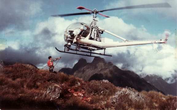 Man waiting to attach strop to helicopter in air