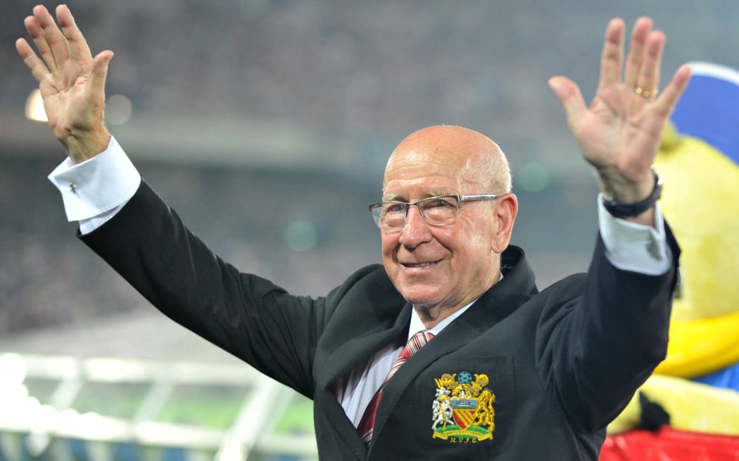 (FILES) English former football player Bobby Charlton waves to Japanese football fans prior to a friendly football  match between Manchester United and Japan's Yokohama F Marinos at Nissan Stadium in Yokohama on July 23, 2013. England World Cup winner and Manchester United great Bobby Charlton has died at the age of 86, it was announced on October 21, 2023. "Manchester United are in mourning following the passing of Sir Bobby Charlton, one of the greatest and most beloved players in the history of our club," the club said in a statement. (Photo by Kazuhiro NOGI / AFP)