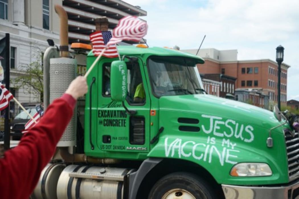 A truck bearing the message &quot;Jesus is my vaccine&quot; blares its siren in support while passing Antiquarantine and pro-Trump protesters on the steps of the Pennsylvania State Capitol in Harrisburg, Pennsylvania.