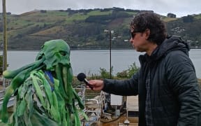 Toby Manhire with Otago Regional Council candidate “Slime the Nitrate Monster” on the banks of Otago Harbour.