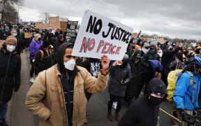 Demonstrators protesting the shooting death of Daunte Wright march to the FBI offices from the Brooklyn Center police station on 13 April 2021 in Brooklyn Center, Minnesota.