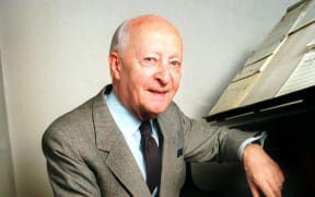 Polish composer Witold Lutosławski sitting at a piano