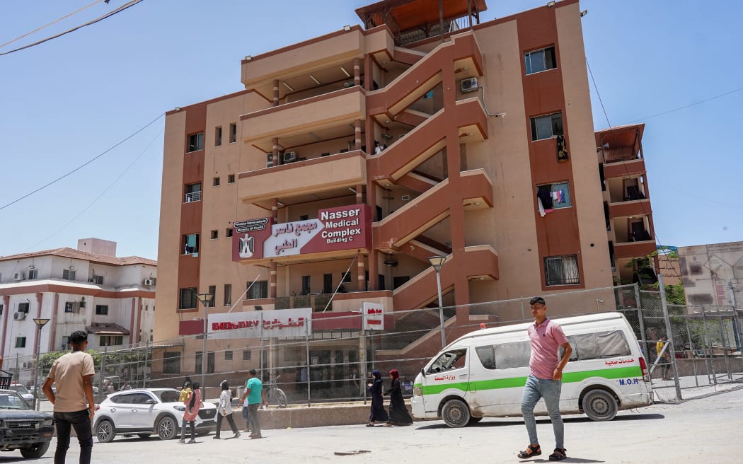 People walk past an ambulance vehicle outside Nasser Medical Complex in Khan Yunis in the southern Gaza Strip on June 18, 2024 amid the ongoing conflict in the Palestinian territory between Israel and Hamas. (Photo by Bashar TALEB / AFP)