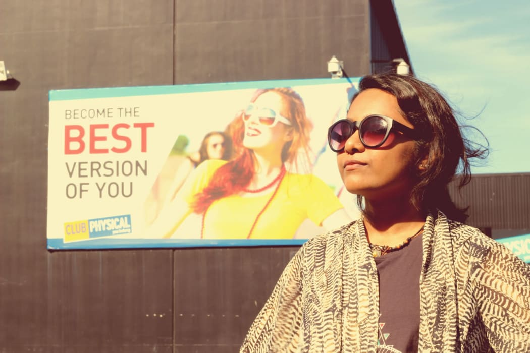 Saziah standing in front of a sign saying "become the best version of you"