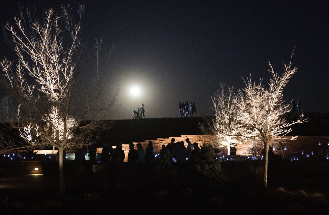 People gather to honor and remember loved ones at the Columbine Memorial at Clement Park in Littleton, Colorado, during a community vigil for the 20th anniversary of the Columbine High School mass shooting on April 19, 2019.