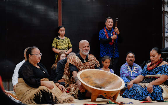 Teokotai Paitai (Taukava, kava mixer) flanked by the Angaikava (assists) tips the tanoa (kava bowl) toward the Olovaha.