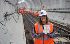 Laurie Winkless and her book in one of London's Cross Rail tunnels being built