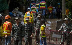 Thai soldiers and volunteers are seen at the entrance of Tham Luang cave.