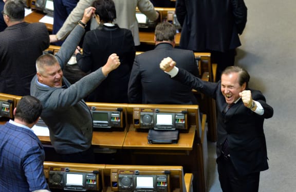 Members of parliament celebrate after the vote.