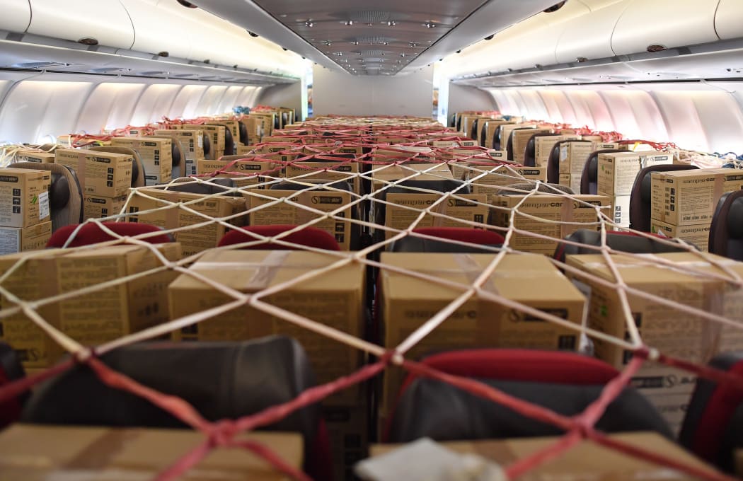 Cargo nets cover boxes of PPE stored on passenger seats inside the cabin of an aircraft, after it landed at Bournemouth Airport in southern England on May 6, 2020(Photo by Ben STANSALL / AFP)