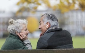 Happy senior couple sharing headphones, listening to music in park. (Photo by Tom Merton/CAIA IMAGE/CAIA IMAGE / NEW / Science Photo Library via AFP)