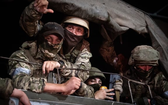 Members of Wagner group looks from a military vehicle in Rostov-on-Don late on June 24, 2023. Rebel mercenary leader Yevgeny Prigozhin who sent his fighters to topple the military leaders in Moscow will leave for Belarus and a criminal case against him will be dropped as part of a deal to avoid "bloodshed," the Kremlin said on June 24. (Photo by Roman ROMOKHOV / AFP)