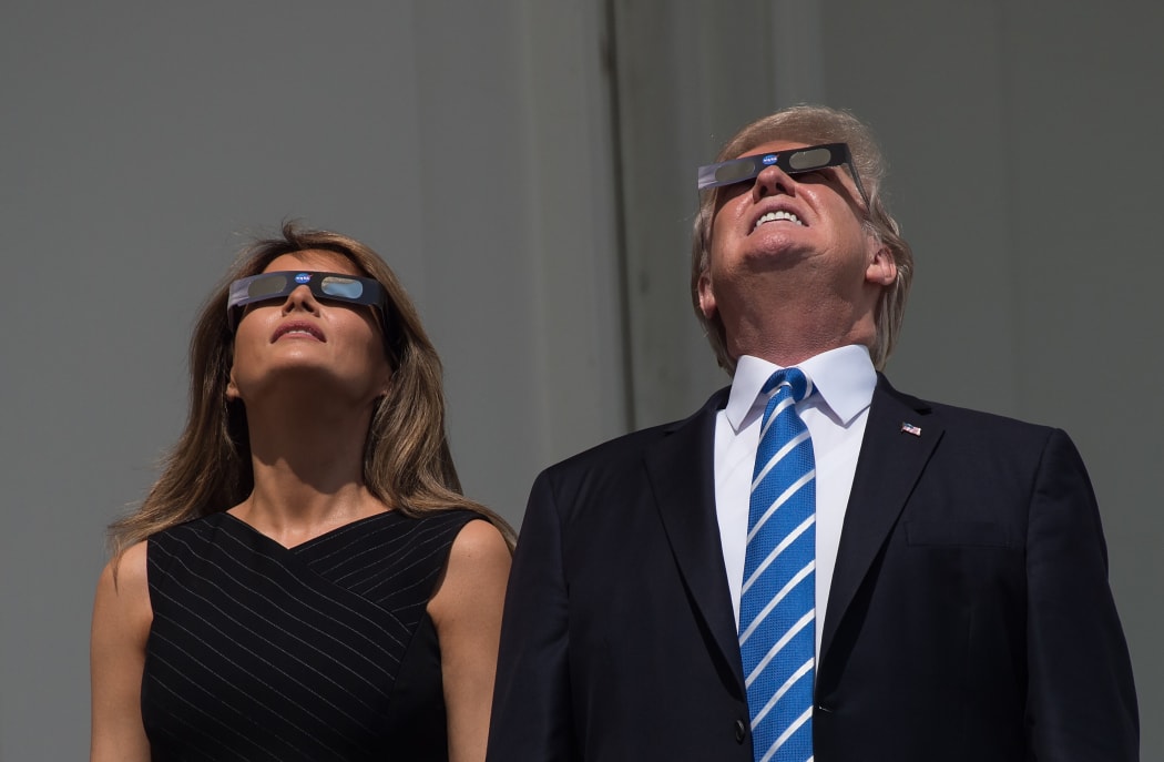 US President Donald Trump and First Lady Melania Trump look up at the partial solar eclipse from the balcony of the White House in Washington, DC, on August 21, 2017.