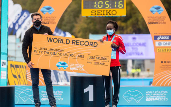 Peres Jepchirchir of Kenya poses with a giant cheque after she set a new world record during women's race at the 2020 IAAF World Half Marathon Championships in Gdynia, Poland, in October 17, 2020.