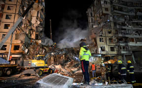 EDITORS NOTE: Graphic content / Rescuers work on a residential building destroyed after a missile strike, in Dnipro on January 15, 2023, amid the Russian invasion of Ukraine. - The death toll rose to at least 20 on January 15 after a strike on a residential building in Dnipro on January 14, a city in centre-east Ukraine, the Ukrainian regional governor said. (Photo by SERGEI CHUZAVKOV / AFP)