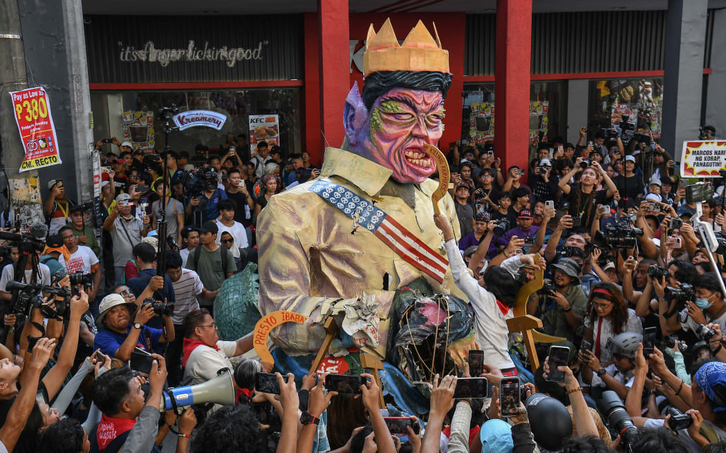 Protesters destroy an effigy of Philippine President Ferdinand Marcos during an anti-corruption rally.