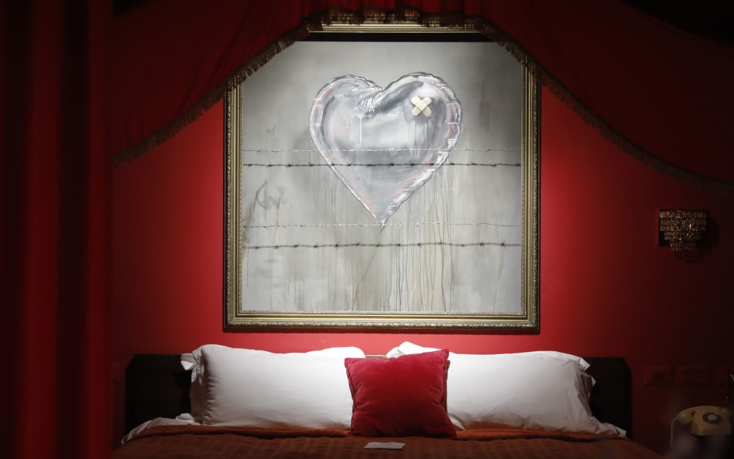 An illustration by street artist Banksy is displayed in his Walled-Off hotel in the Israeli occupied West Bank town of Bethlehem on December 20, 2019.
