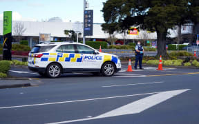 Police keep watch outside the Countdown supermarket at LynnMall.