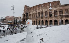 A snowman is seen in front of the ancient Colosseum during a heavy snowfall on February 26, 2018 in Rome.