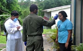 A soldier helps mobile screening teams carry out door-to-door tests in Suva.