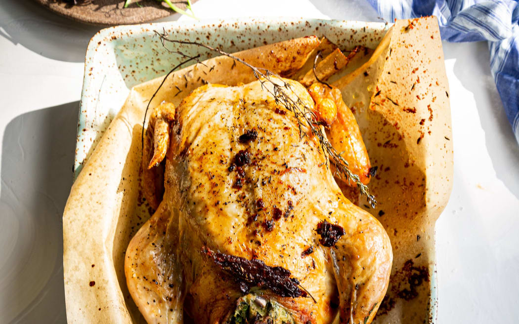 An image of a roast chicken with green stuffing.
