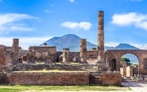 Mount Vesuvius is seen behind the remnants of an ancient temple which was buried with the city of Pompeii.