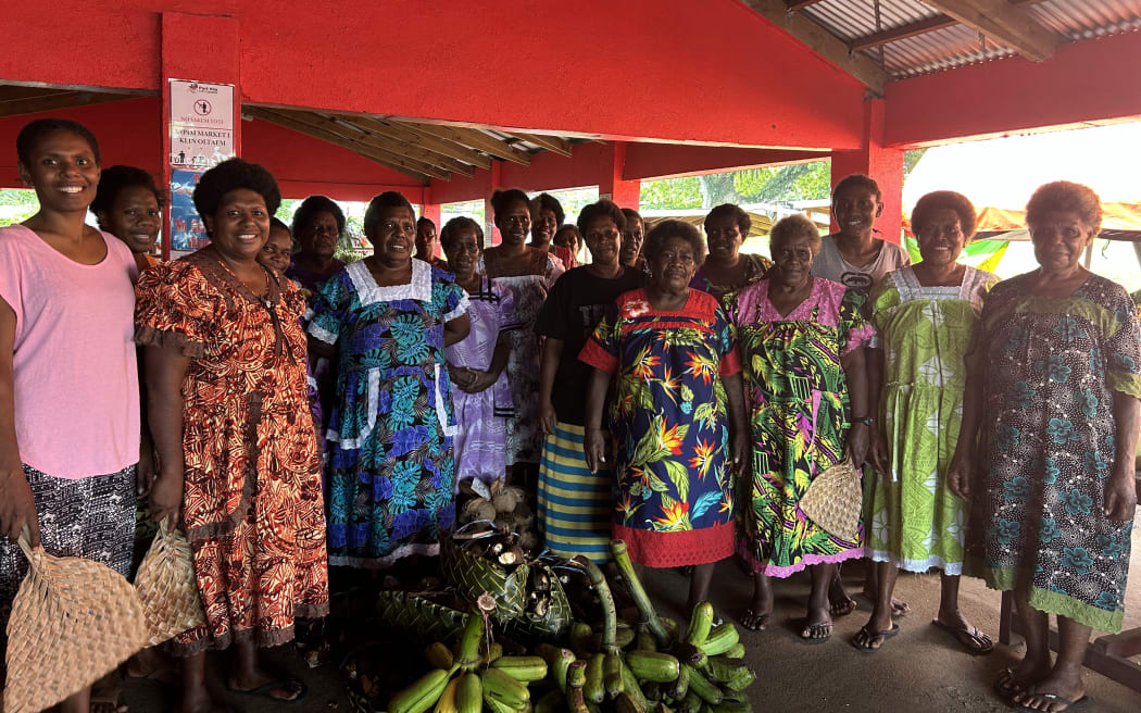 At the Port Vila Show Ground Market, groups of women sold their produce under a marquee-style tarpaulin shelter set up beside a permanent concrete verandah.