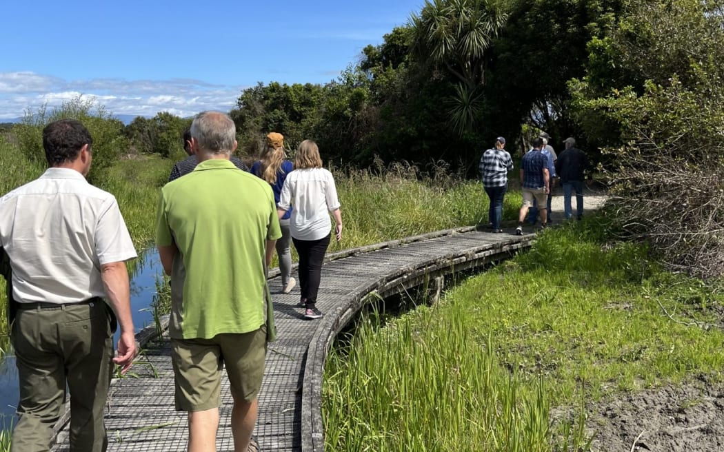 West Coast Conservation Board members and DOC staff walk across an existing bridge, with walkways through the site being improved and extended.