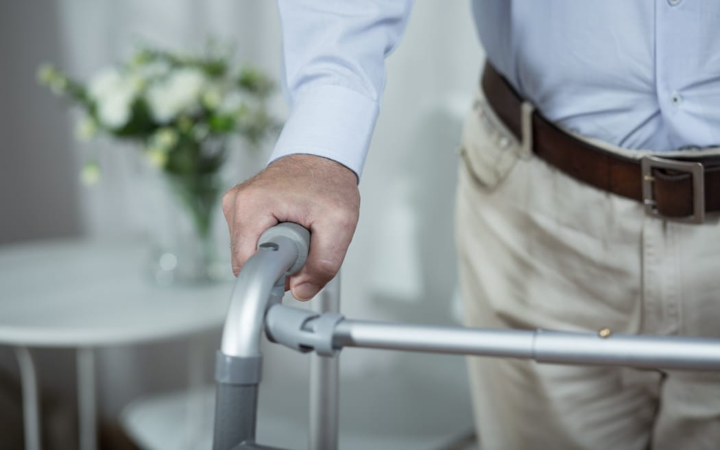 Elderly man. Walking frame. Retirement home.