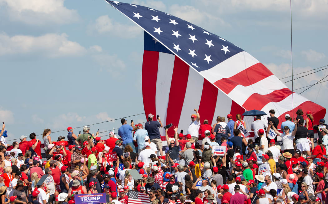 A giant American flag waves over Trump supporters as the former US President speaks, before shots rang out at a rally in Butler, Pennsylvania, on 13 July, 2024.