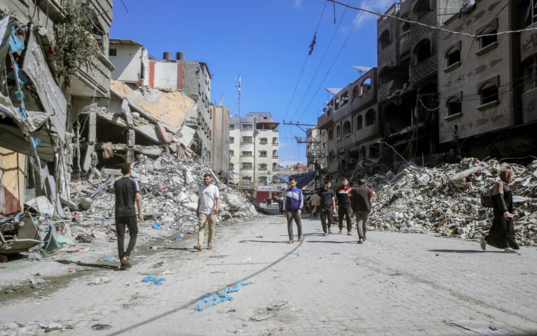 10/15/2023 Gaza, Palestine. People walking amidst the destruction of houses and streets in Khan Yunis, located in the southern Gaza Strip, amid the devastation caused by Israeli airstrikes. (Photo by Mohamed Zaanoun / Middle East Images / Middle East Images via AFP)