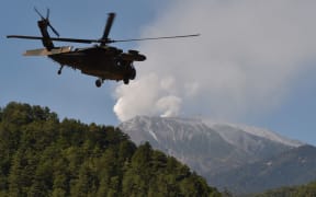 A military helicopter leaves a temporary landing site for a rescue mission on Japan's Mount Ontake.