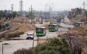 Buses sent to evacuate residents from Fuaa and Kafraya villages arrive at a rebel-held checkpoint on the outskirts of the two Syrian villages under rebel siege, on December 18, 2016.