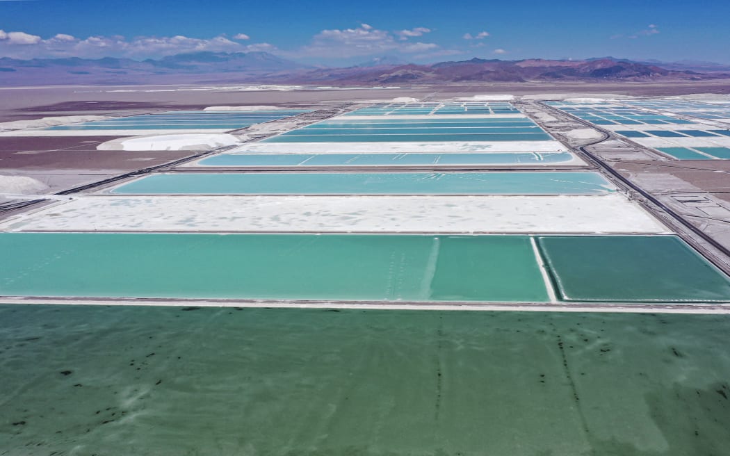 Aerial view of brine ponds and processing areas of the lithium mine of the Chilean company SQM (Sociedad Quimica Minera) in the Atacama Desert, Calama, Chile, on September 12, 2022. The turquoise glimmer of open-air pools meets the dazzling white of a seemingly endless salt desert where hope and disillusionment collide in Latin America's "lithium triangle." A key component of batteries used in electric cars, demand has exploded for the "white gold" found in Argentina, Bolivia and Chile in quantities larger than anywhere else in the world. (Photo by Martin BERNETTI / AFP)