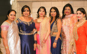 Baljit Dheil (second from left), stands next to Abha Khanna, and Soni Dheil celebrate their culture with other women.